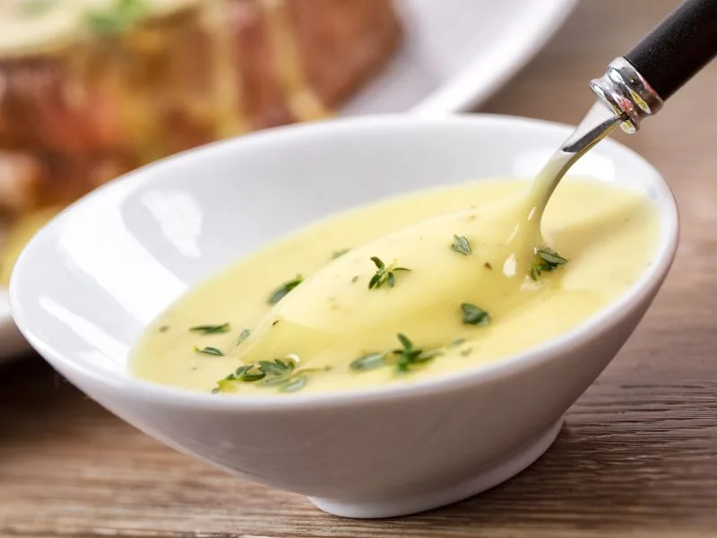 Salsa Bernese preparata con Olio Extravergine di Oliva servita accanto a un piatto di carne
