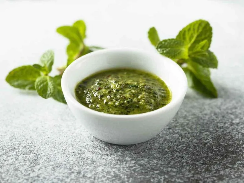 Pesto di menta fresco preparato con olio extravergine di oliva in un mortaio