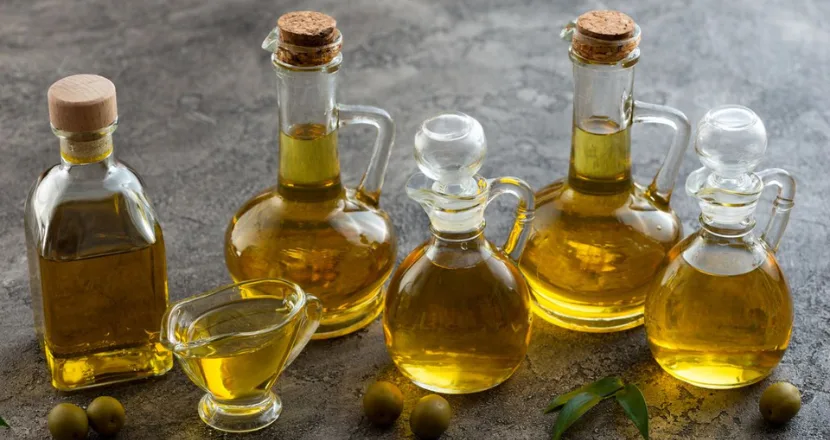 Bottiglie di olio di oliva con etichette di classificazione — extravergine, vergine, raffinato