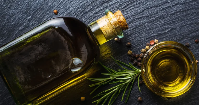 Diverse soluzioni di packaging sostenibile per l'olio d'oliva: bottiglie di vetro riciclato, confezioni in cartone e bioplastiche